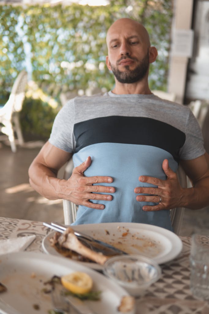 Man with hands on his abdomen suffering after eating too much